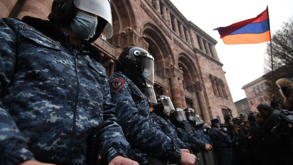Сотрудники полиции стоят в оцеплении перед зданием правительства Армении во время митинга оппозиции на площади Республики в Ереване