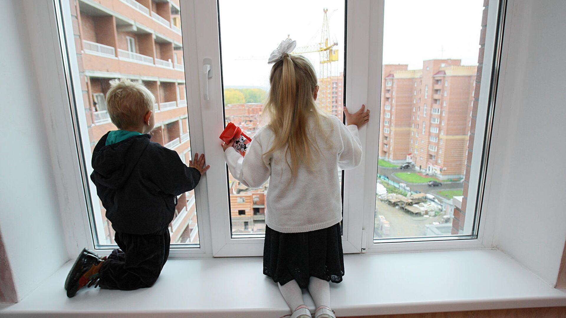 Дети смотрят в окно из новой квартиры - РИА Новости, 1920, 09.03.2021