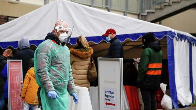 Медицинский работник у больницы, где проходит добровольное экспресс-тестированию на коронавирус, в Праге