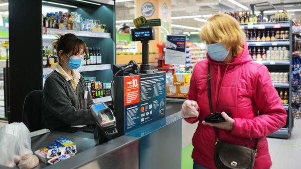 Покупатель оплачивает покупки на кассе в супермаркете Перекресток