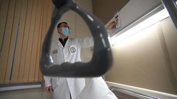 Врач демонстрирует кнопку вызова в палате первого стационара-трансформера для пациентов с коронавирусом в Санкт-Петербурге