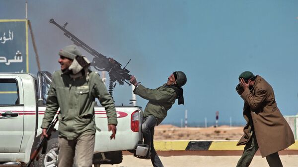Боец оппозиции стреляет из пулемета в истребитель в городе Рас-Лануф