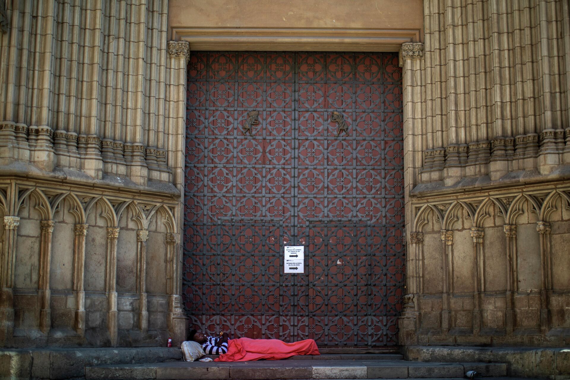 Мужчина у главных ворот церкви, частично закрытой в Барселоне, Испания - РИА Новости, 1920, 25.12.2020