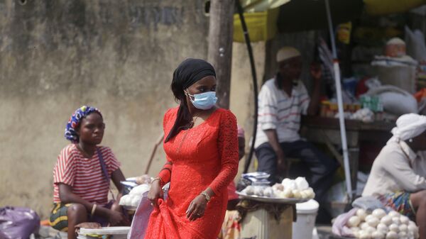 Женщина в медицинской маске на рынке в Лагосе, Нигерия