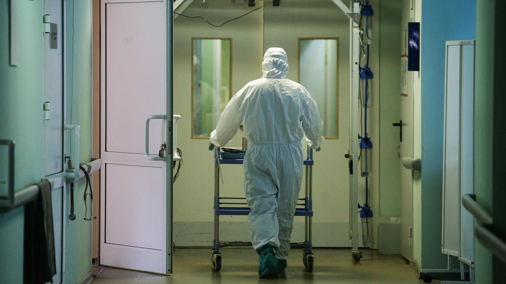 Медик в защитном противоэпидемическом костюме в коридоре Новосибирской областной клинической больницы - РИА Новости, 1920, 20.02.2021
