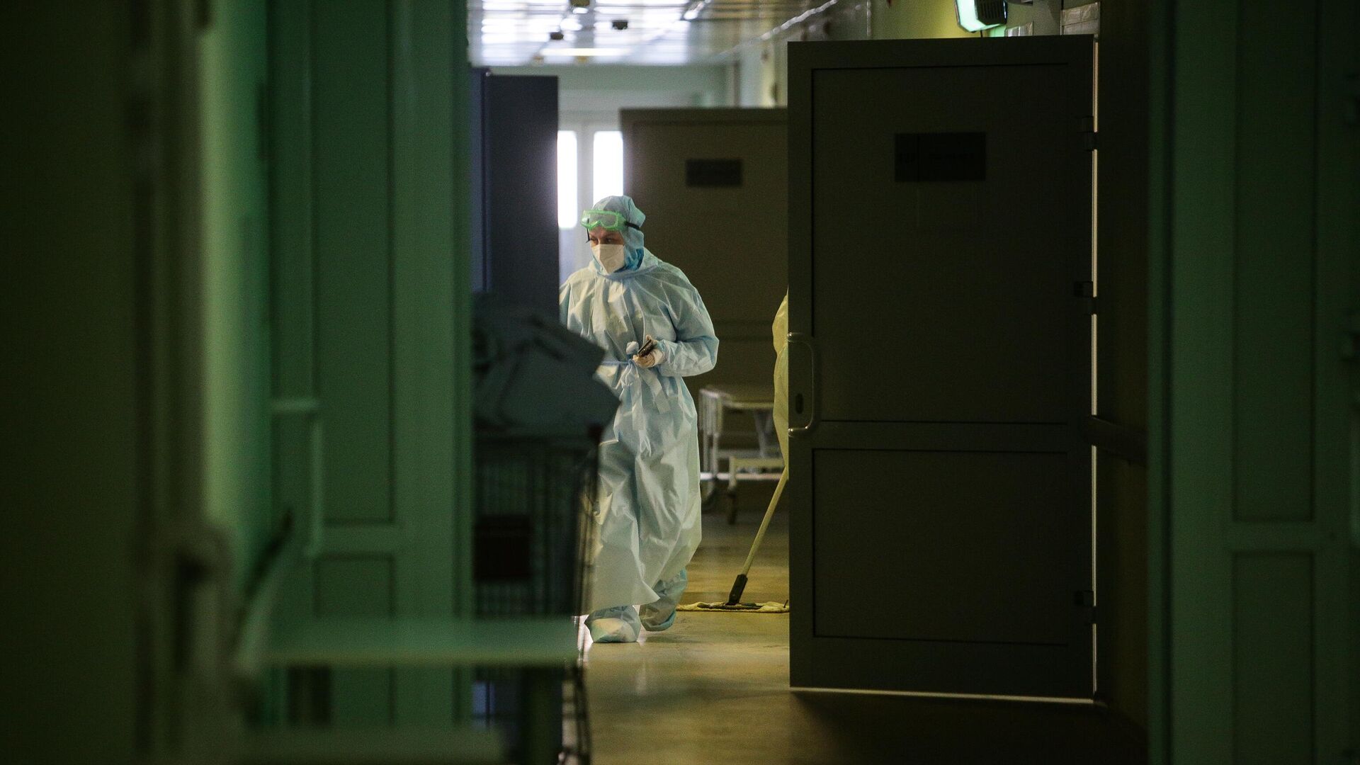 Медик в защитном противоэпидемическом костюме идет по коридору Новосибирской областной клинической больницы - РИА Новости, 1920, 20.01.2021