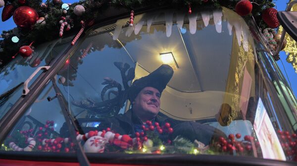 Водитель праздничного Дедморобуса с музыкантами в костюмах Дедов Морозов, который ездит по улицам Санкт-Петербурга в преддверии нового года