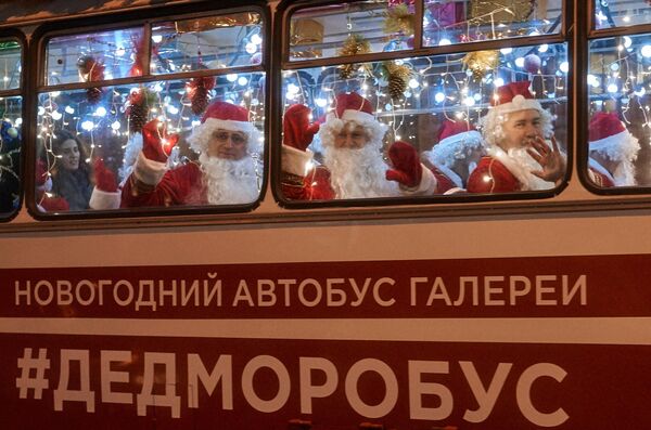 Музыканты в костюмах Дедов Морозов в новогоднем автобусе с оркестром Дедморобусе на Невском проспекте в Санкт-Петербурге
