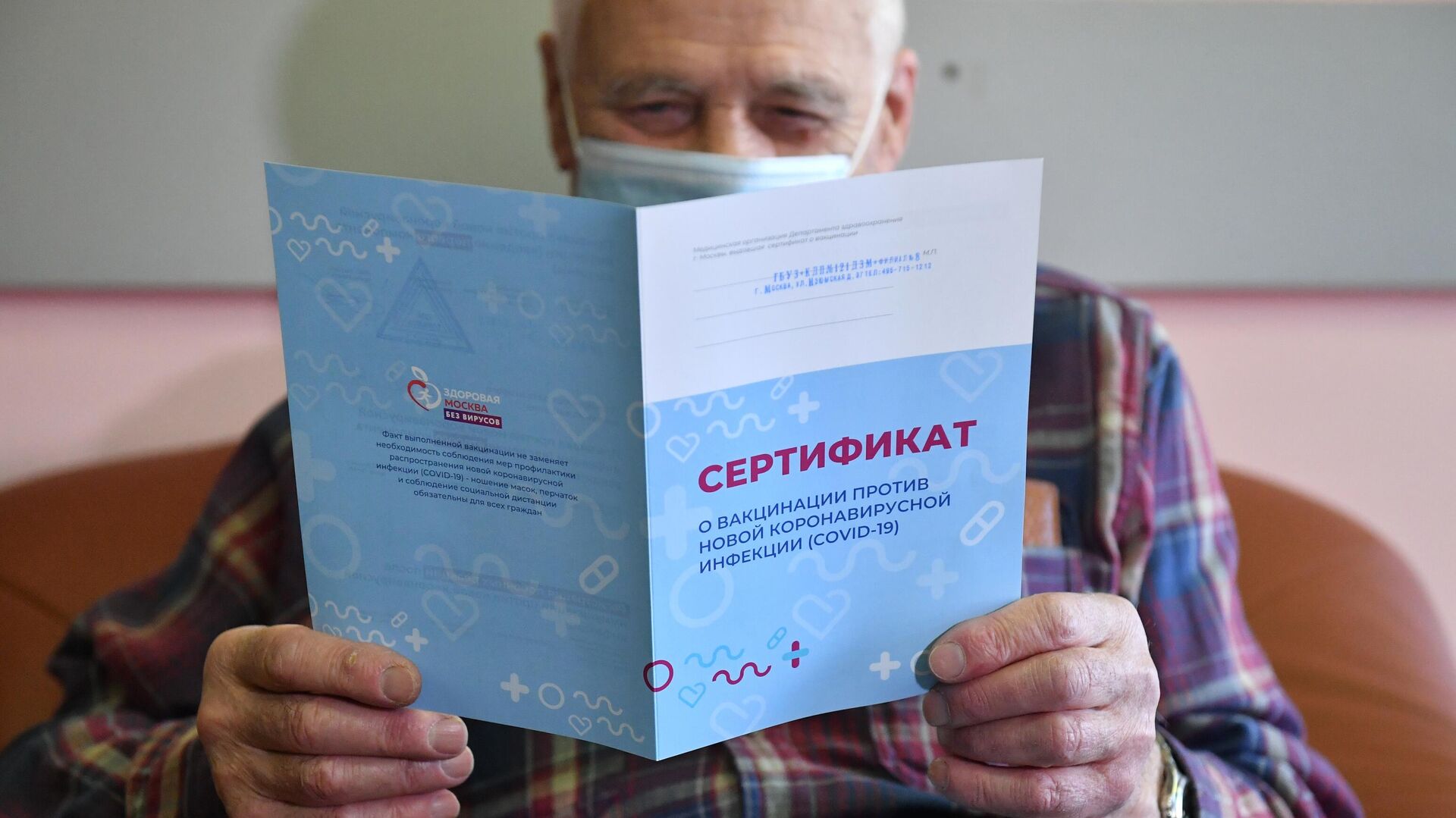 Мужчина держит в руках сертификат о вакцинации против коронавирусной инфекции (COVID-19) - РИА Новости, 1920, 03.03.2021