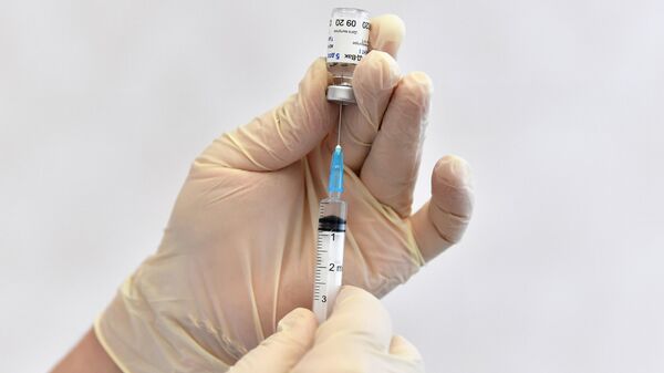 Медицинская сестра набирает в шприц вакцину Гам-КОВИД-Вак в процедурном кабинете