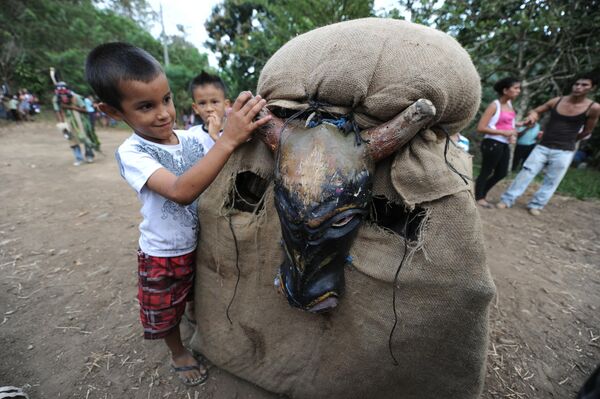 Ребенок племени борука играет с костюмом быка на фестивале дьяволят в Коста-Рике 