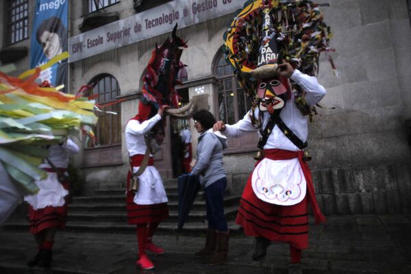Отдыхающие в масках быков и национальных костюмах на фестивале в Ламегу на севере Португалии 