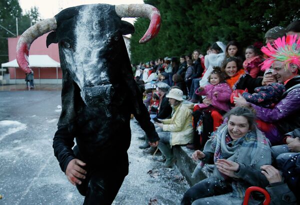 Человек в костюме быка на карнавале в городе Устариц, Франция 