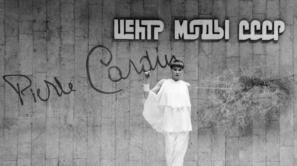 Манекенщица демонстрирует белый костюм на показе моделей одежды французского модельера Пьера Кардена