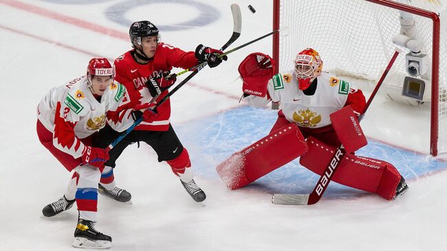 EDMONTON, AB - JANUARY 04: Dylan Holloway #10 of Canada battles against Yan Kuznetsov #2 and goaltender Yaroslav Askarov #1 of Russia during the 2021 IIHF World Junior Championship semifinals at Rogers Place on January 4, 2021 in Edmonton, Canada.   Codie McLachlan/Getty Images/AFP