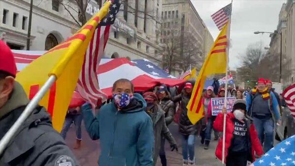 Жители Вашингтона с огромным флагом США прошли по улицам в поддержку Трампа