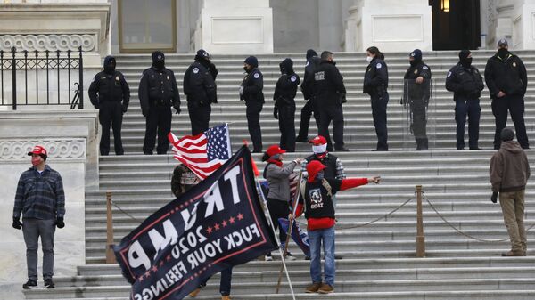 Сотрудники полиции и участники акции протеста сторонников действующего президента США Дональда Трампа у здания конгресса в Вашингтоне