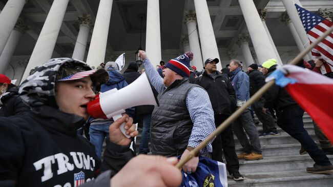 Участники акции протеста сторонников действующего президента США Дональда Трампа у здания конгресса в Вашингтоне