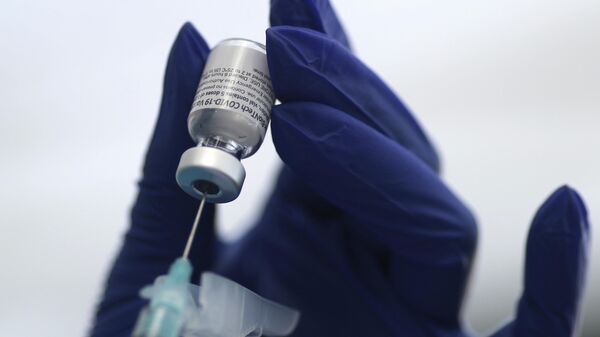 Флакон с вакциной от COVID-19 компаний Pfizer и BioNTech во время вакцинации в Лос-Анджелесе