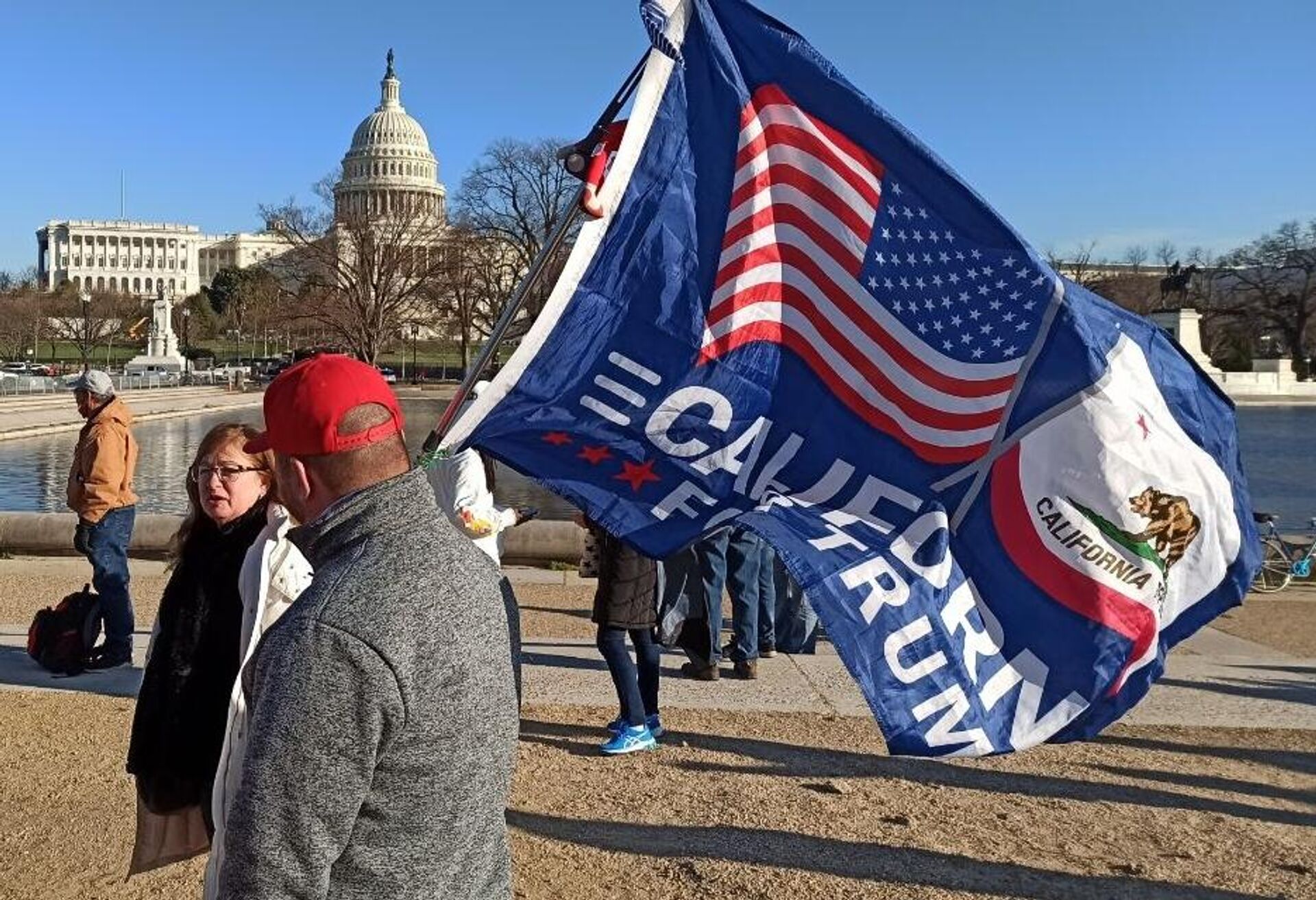 Мужчина с флагом сторонников Дональда Трампа на Капитолийском холме в Вашингтоне - РИА Новости, 1920, 20.01.2022