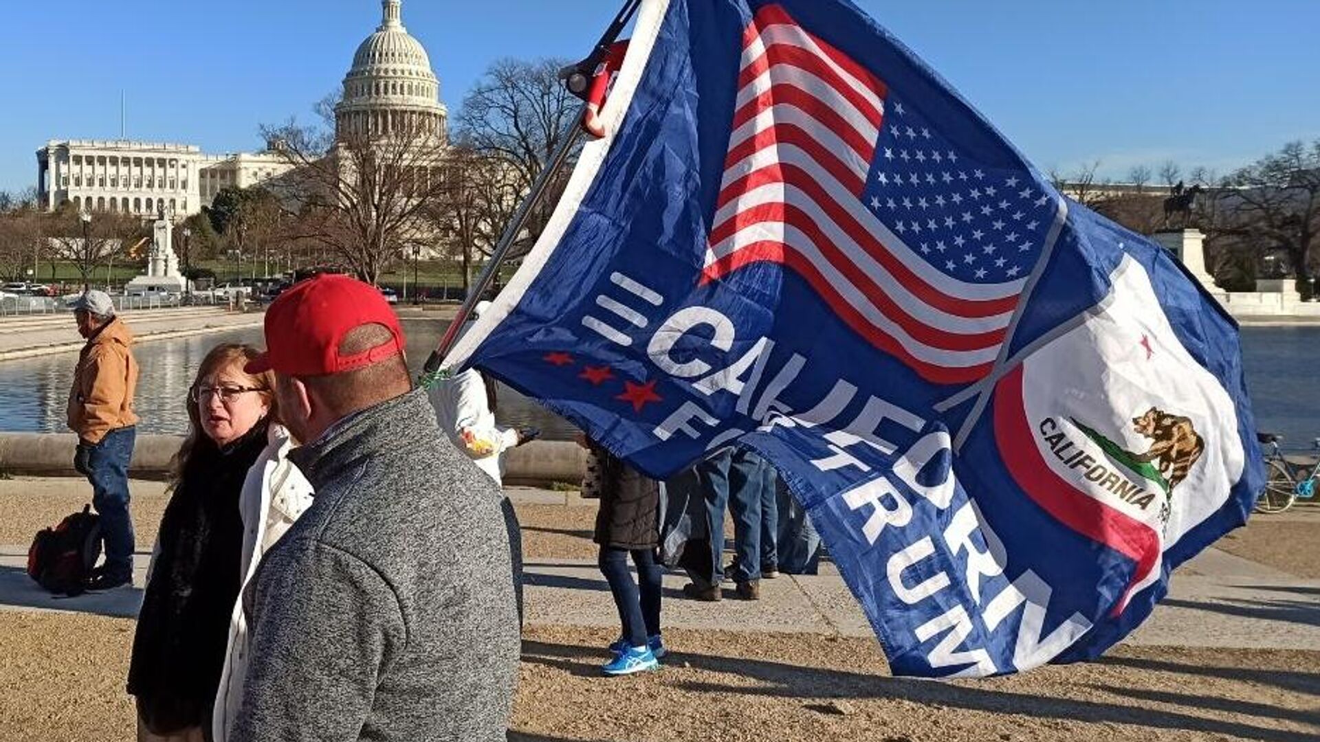 Мужчина с флагом сторонников Дональда Трампа на Капитолийском холме в Вашингтоне - РИА Новости, 1920, 09.01.2021