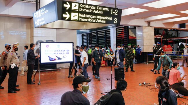 Представители СМИ в аэропорту Сукарно-Хатта в Джакарте, после крушения самолета компании Sriwijaya Air