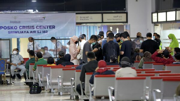 Люди в кризисном центре, организованном в аэропорту Сукарно-Хатта в Джакарте, после крушения самолета компании Sriwijaya Air