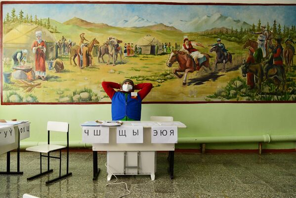 Сотрудник избирательной комиссии на избирательном участке во время досрочных выборов президента Кыргызской Республики в Бишкеке