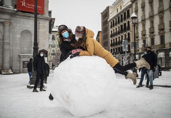 Девушки прыгают на гигантский снежок на одной из улиц в Мадриде