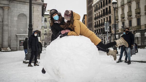 Девушки прыгают на гигантский снежок на одной из улиц в Мадриде