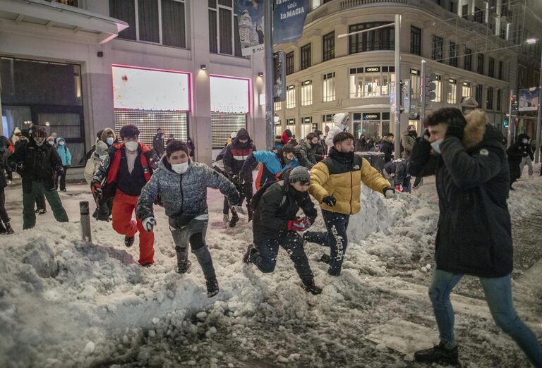 Люди играют в снежки на площади Кальяо в Мадриде