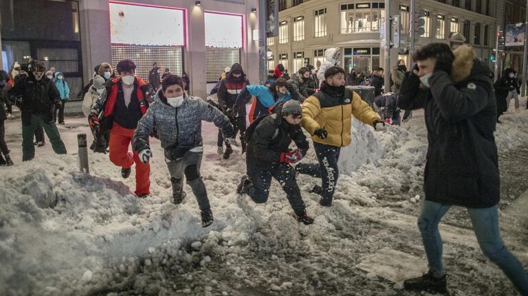 Люди играют в снежки на площади Кальяо в Мадриде