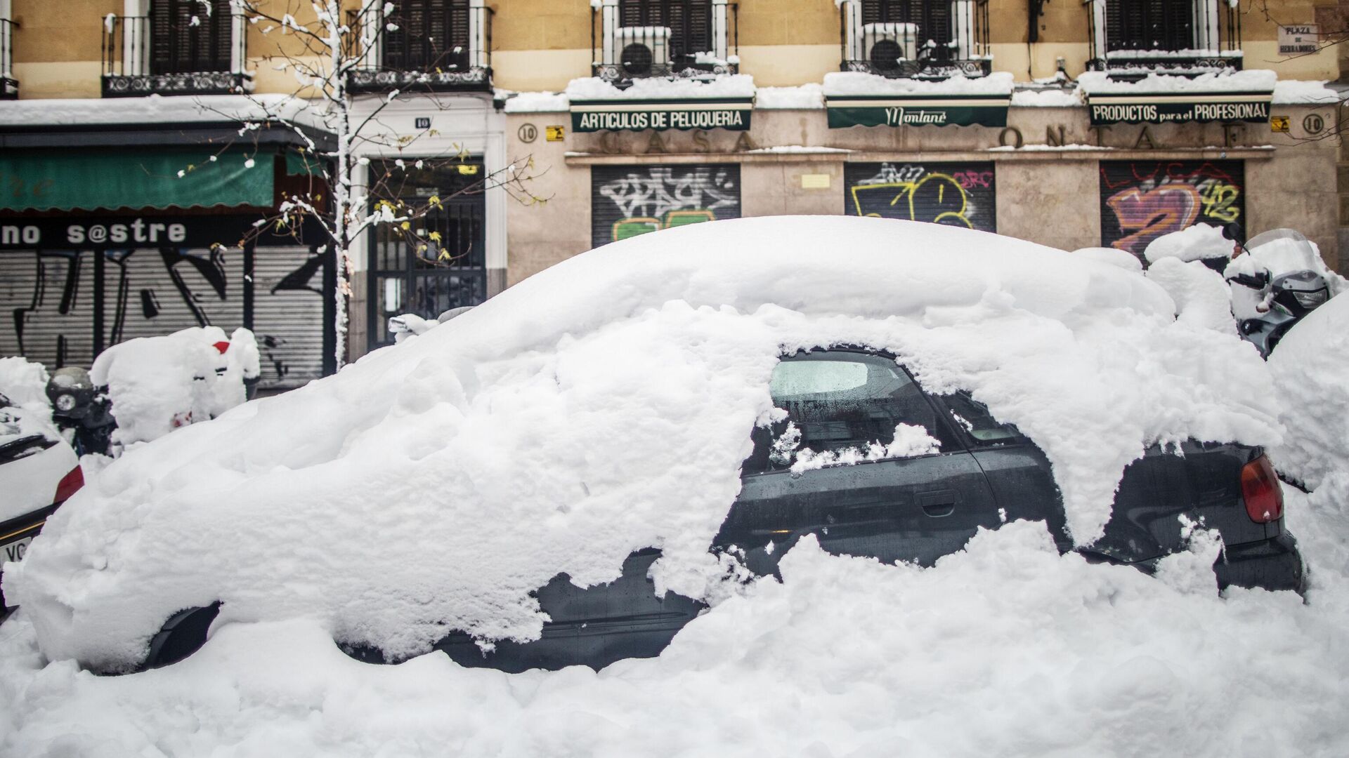 Занесенный снегом автомобиль на одной из улиц в Мадриде - РИА Новости, 1920, 23.01.2021
