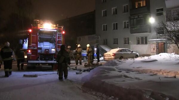 Сотрудники пожарной службы во дворе жилого дома на улице Рассветной в Екатеринбурге, где произошел пожар