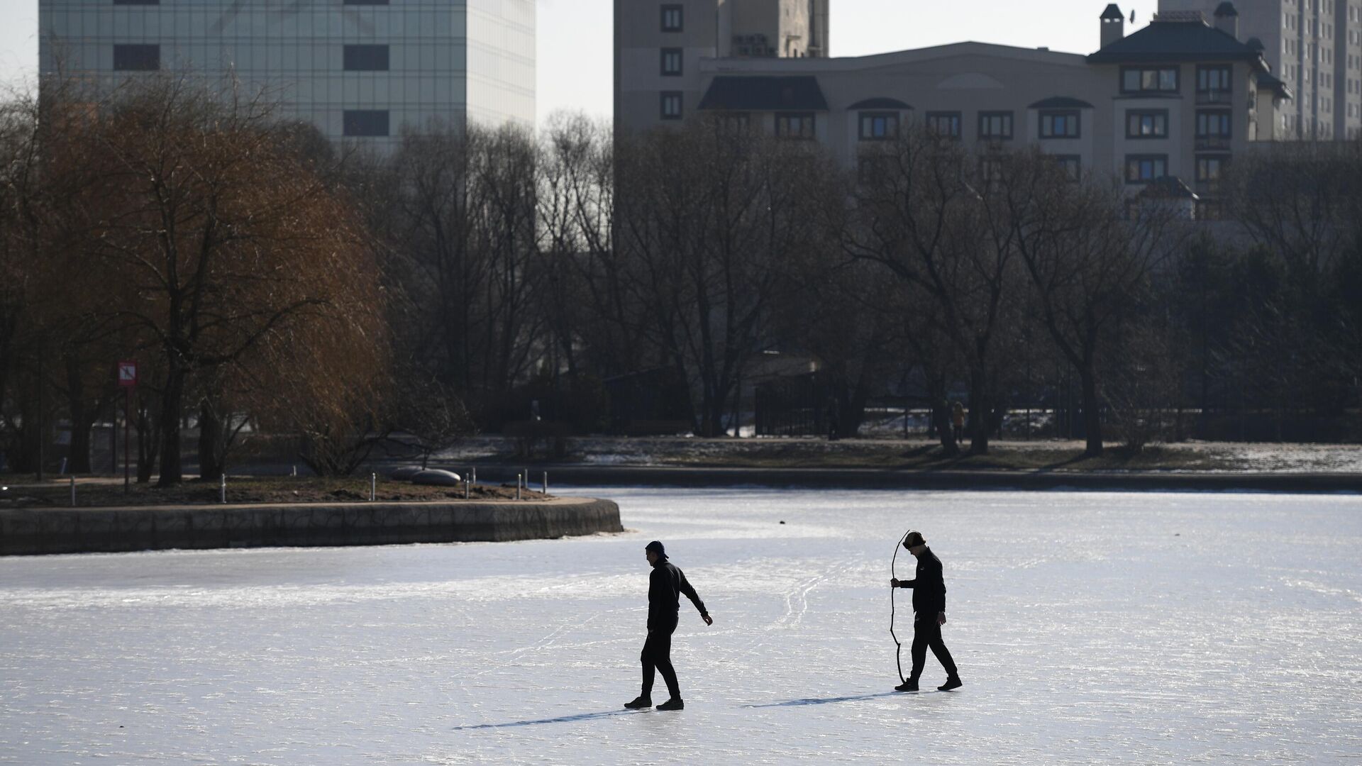 Мужчины ходят по замерзшему пруду в парке Дружбы в Москве - РИА Новости, 1920, 12.01.2021