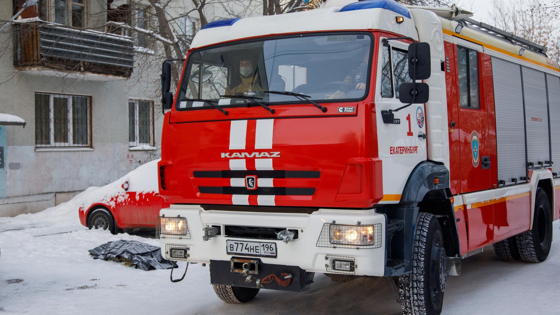 Автомобиль пожарной службы по дворе жилого дома на улице Рассветной в Екатеринбурге, где произошел пожар - РИА Новости, 1920, 01.02.2021