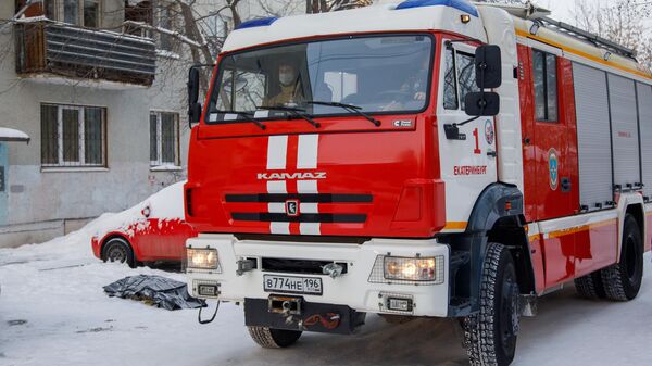 Автомобиль пожарной службы по дворе жилого дома на улице Рассветной в Екатеринбурге, где произошел пожар
