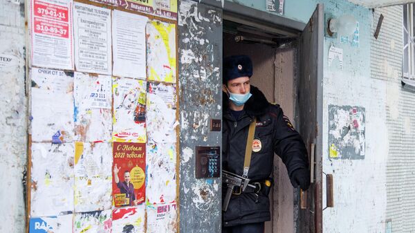 Сотрудник полиции в подъезде жилого дома на улице Рассветной в Екатеринбурге, где произошел пожар