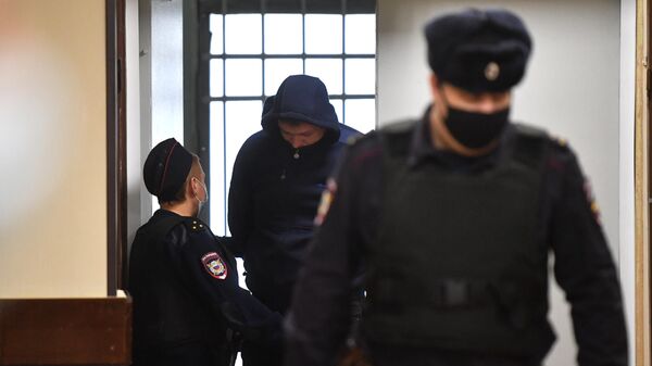 Сотрудники полиции сопровождают Ивана Гаврикова, протаранившего на самосвале колонну военных автобусов в Подмосковье