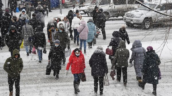 Прохожие во время снегопада во Владивостоке