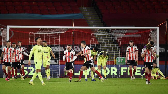 Sheffiled players celebrate at the final whistle during the English Premier League football match between Sheffield United and Newcastle United at Bramall Lane in Sheffield, northern England on January 12, 2021. - Sheffield won the match 1-0. (Photo by Oli SCARFF / POOL / AFP) / RESTRICTED TO EDITORIAL USE. No use with unauthorized audio, video, data, fixture lists, club/league logos or 'live' services. Online in-match use limited to 120 images. An additional 40 images may be used in extra time. No video emulation. Social media in-match use limited to 120 images. An additional 40 images may be used in extra time. No use in betting publications, games or single club/league/player publications. / 