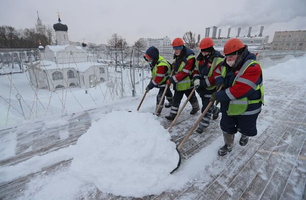 Сотрудники ГБУ Гормост проводят чистку снега и наледи на Парящем мосту в парке Зарядье в Москве