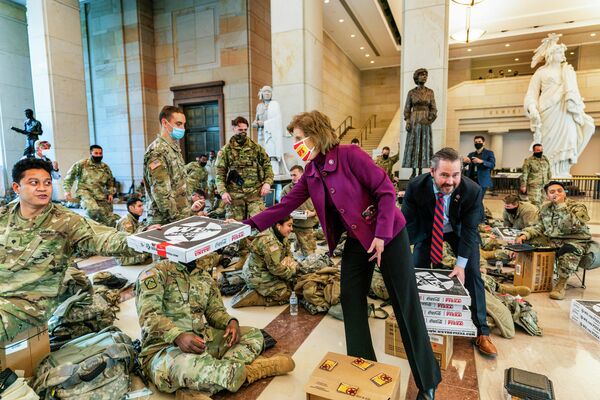 Член палаты представителей США Вики Хартцлер и Майкл Уолтц угощают пиццей военнослужащих Национальной гвардии в здании Капитолия в Вашингтоне