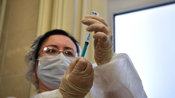 Медработник во время вакцинации от коронавируса COVID-19 вакциной Спутник V в Москве
