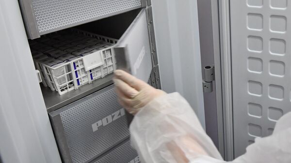 Медработник достает из холодильника вакцину Спутник V от коронавируса COVID-19 