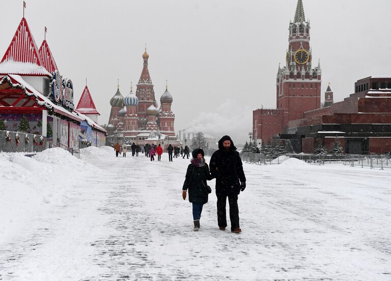 Прохожие на заснеженной Красной площади в Москве