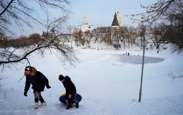 Дети катаются на ватрушке возле Новоспасского монастыря в Москве
