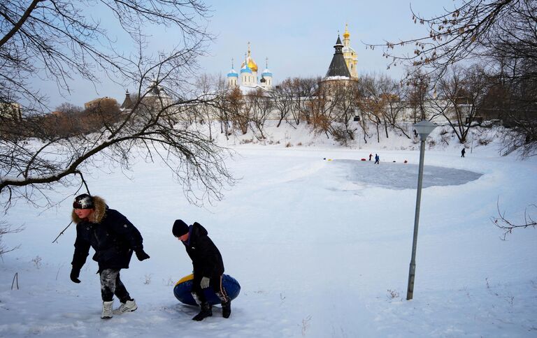 Дети катаются на ватрушке возле Новоспасского монастыря в Москве