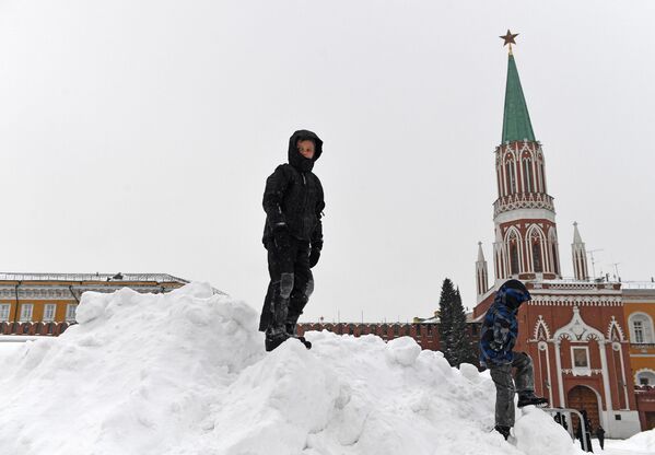 Дети играют на снежной горке на Красной площади в Москве