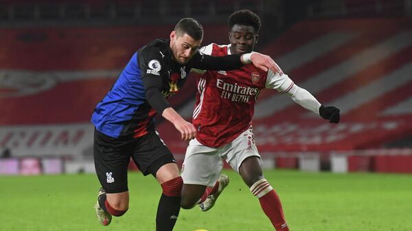 Crystal Palace's English defender Joel Ward (L) vies with Arsenal's English striker Bukayo Saka (R) during the English Premier League football match between Arsenal and Crystal Palace at the Emirates Stadium in London on January 14, 2021. (Photo by NEIL HALL / POOL / AFP) / RESTRICTED TO EDITORIAL USE. No use with unauthorized audio, video, data, fixture lists, club/league logos or 'live' services. Online in-match use limited to 120 images. An additional 40 images may be used in extra time. No video emulation. Social media in-match use limited to 120 images. An additional 40 images may be used in extra time. No use in betting publications, games or single club/league/player publications. / 